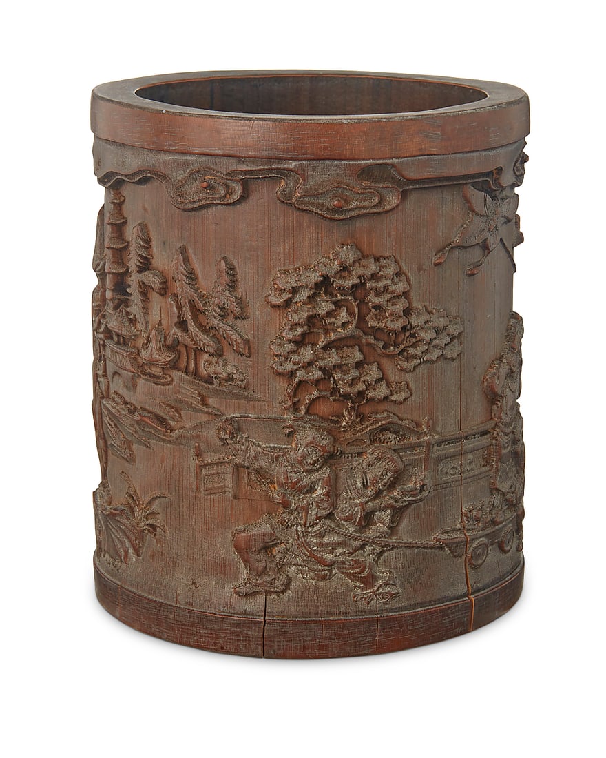 A Chinese carved bamboo brush pot 20th century Carved with figures within a village scene 6.625" H: A Chinese carved bamboo brush pot 20th century Carved with figures within a village scene 6.625" H x 5.5" Dia. (irregular)