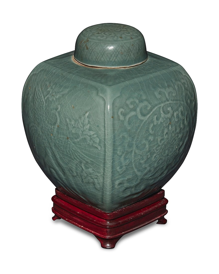 A Chinese celadon porcelain ginger jar Late Qing Dynasty (1644-1912) or later Decorated with two: A Chinese celadon porcelain ginger jar Late Qing Dynasty (1644-1912) or later Decorated with two phoenix figures and scrolled motifs in low relief, raised on a hardwood stand Jar: 9.125" H x 7.75" W x