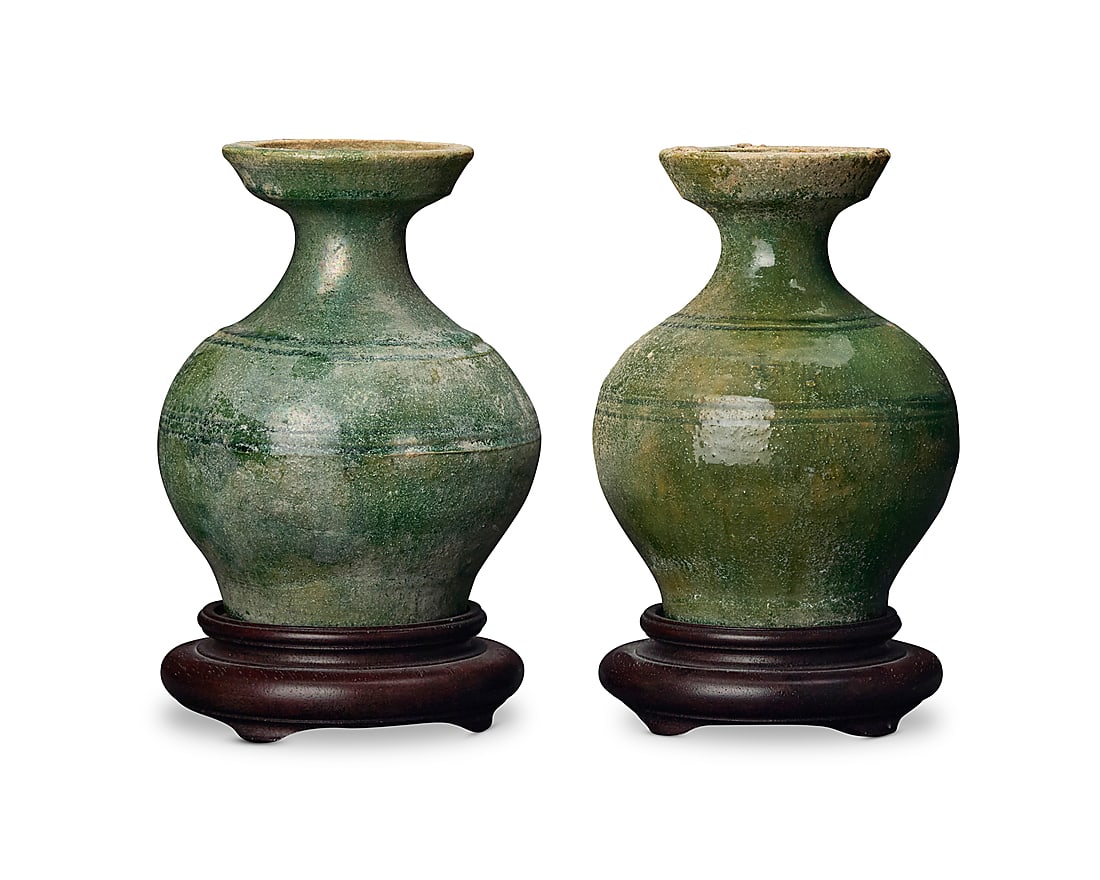 Two Chinese green glazed pottery pear form vases Han Dynasty (206 BCE-220 CE) or style Each raised: Two Chinese green glazed pottery pear form vases Han Dynasty (206 BCE-220 CE) or style Each raised on a carved hardwood stand 2 pieces Each: 6.25" H x 4.875" Dia. approximately; Each stand: 1.5" H x 4