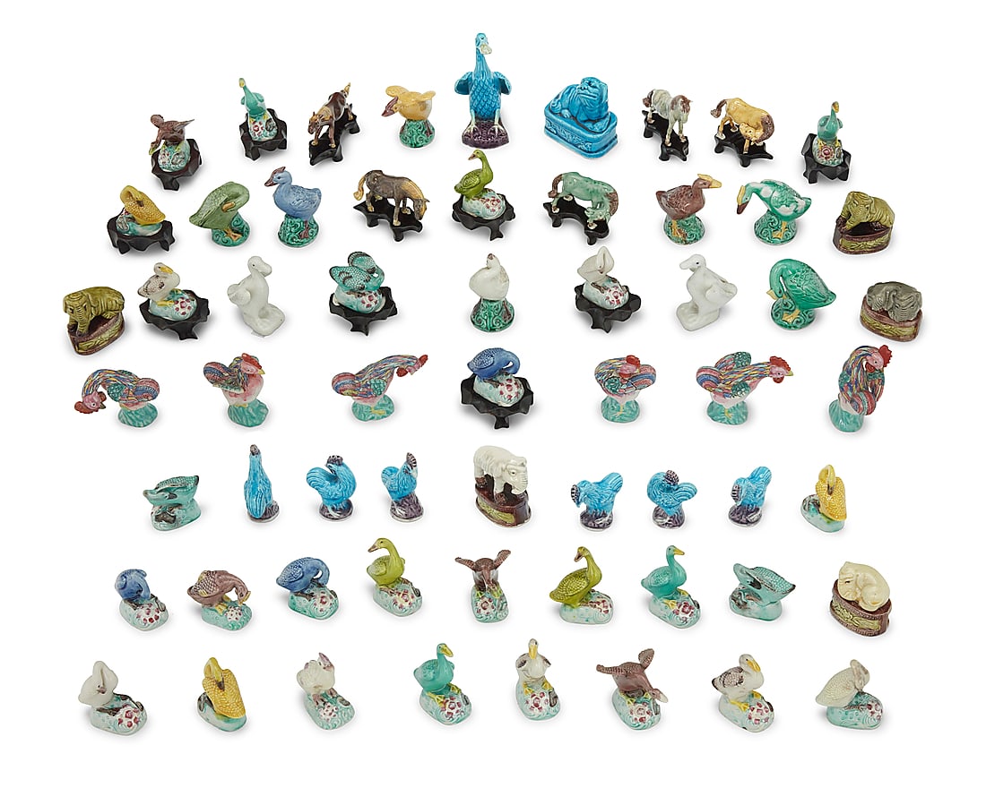 A large group of miniature Chinese glazed pottery figures 20th century Comprising ducks, geese,: A large group of miniature Chinese glazed pottery figures 20th century Comprising ducks, geese, elephants, horses, and various other animals, most with wood stands 60 pieces approximately Tallest: 4.5