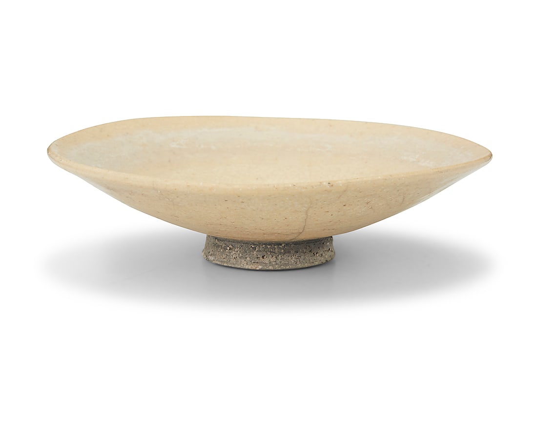 An Asian style pale yellow glazed ceramic bowl 20th century With illegible incised signature to: An Asian style pale yellow glazed ceramic bowl 20th century With illegible incised signature to underside foot and dated, reading '47' or '97' Of shallow footed form 2" H x 7" Dia.
