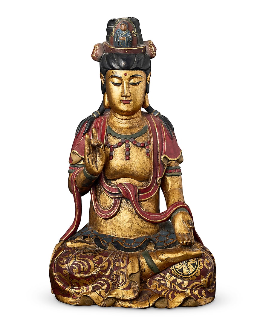 An Asian carved giltwood figure of the Buddha 20th century Polychrome decorated, depicted seated: An Asian carved giltwood figure of the Buddha 20th century Polychrome decorated, depicted seated with hands in karana mudra 20" H x 11.75" W x 9.5" D Provenance: The Grace Family Collection, St. Helen