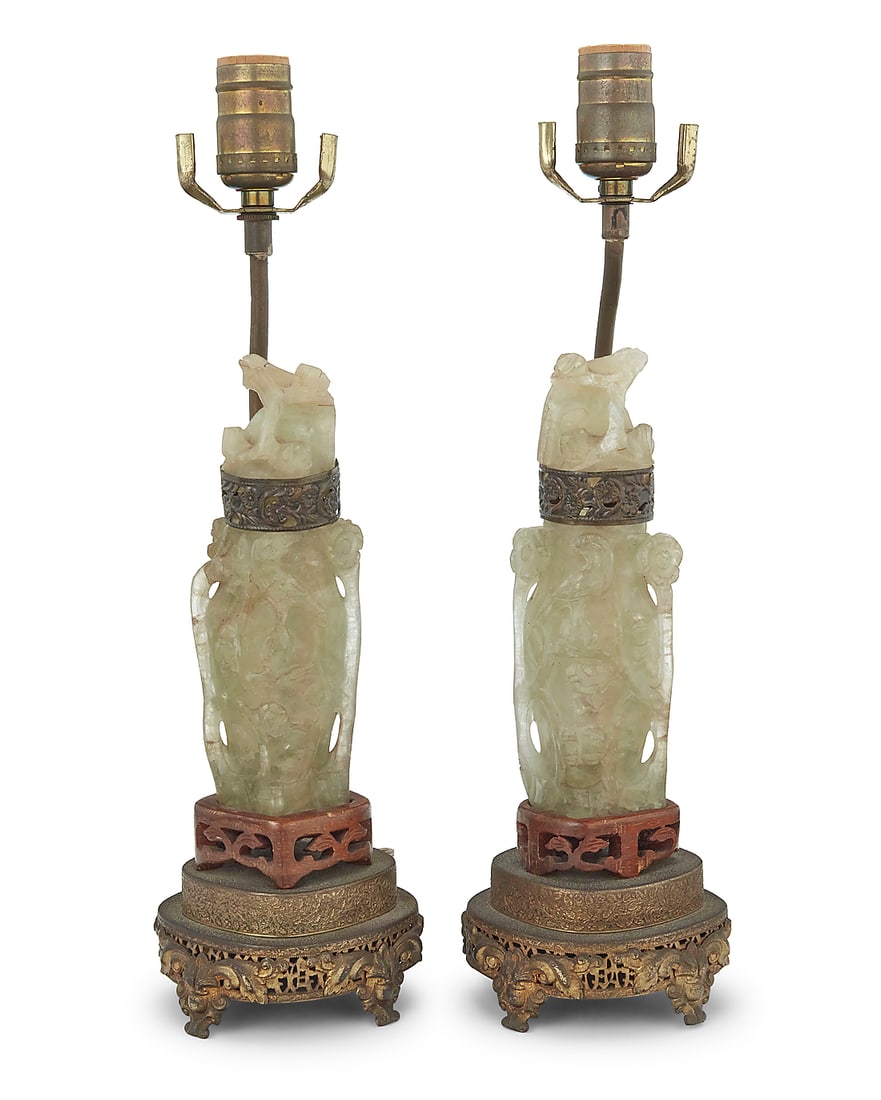 A pair of Chinese carved hardstone table lamps 20th century Comprising two lidded urns, each: A pair of Chinese carved hardstone table lamps 20th century Comprising two lidded urns, each depicting bird motifs and converted to a single-light lamp with a pierced gilt-metal base, electrified 2 pi