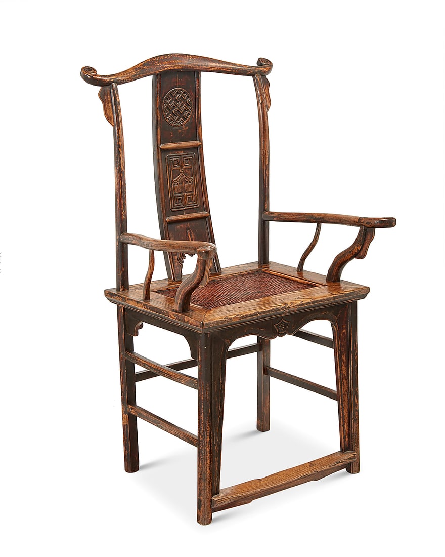A Chinese carved wood 'official's hat' armchair 20th century The chair with yolk back crest rail: A Chinese carved wood 'official's hat' armchair 20th century The chair with yolk back crest rail above a curved splat carved with medallions, above a seat with inset caning and fabric-upholstered cush