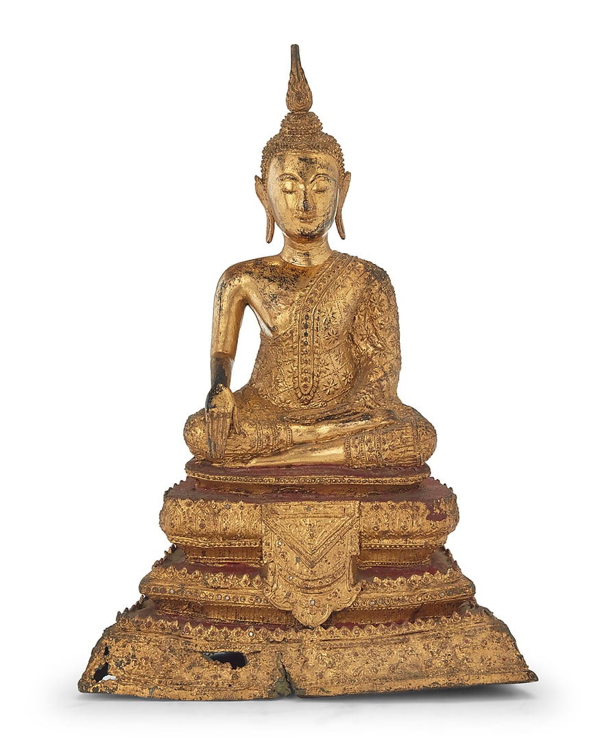 A Burmo Thai gilt metal Buddha figure: A Burmo Thai gilt metal Buddha figure Rattanakosin Period (1782-1932) With inset glass accents, depicted with hands in bhumisparsha mudra, seated on a tiered base 15.25" H x 10.5" W x 6.375" D