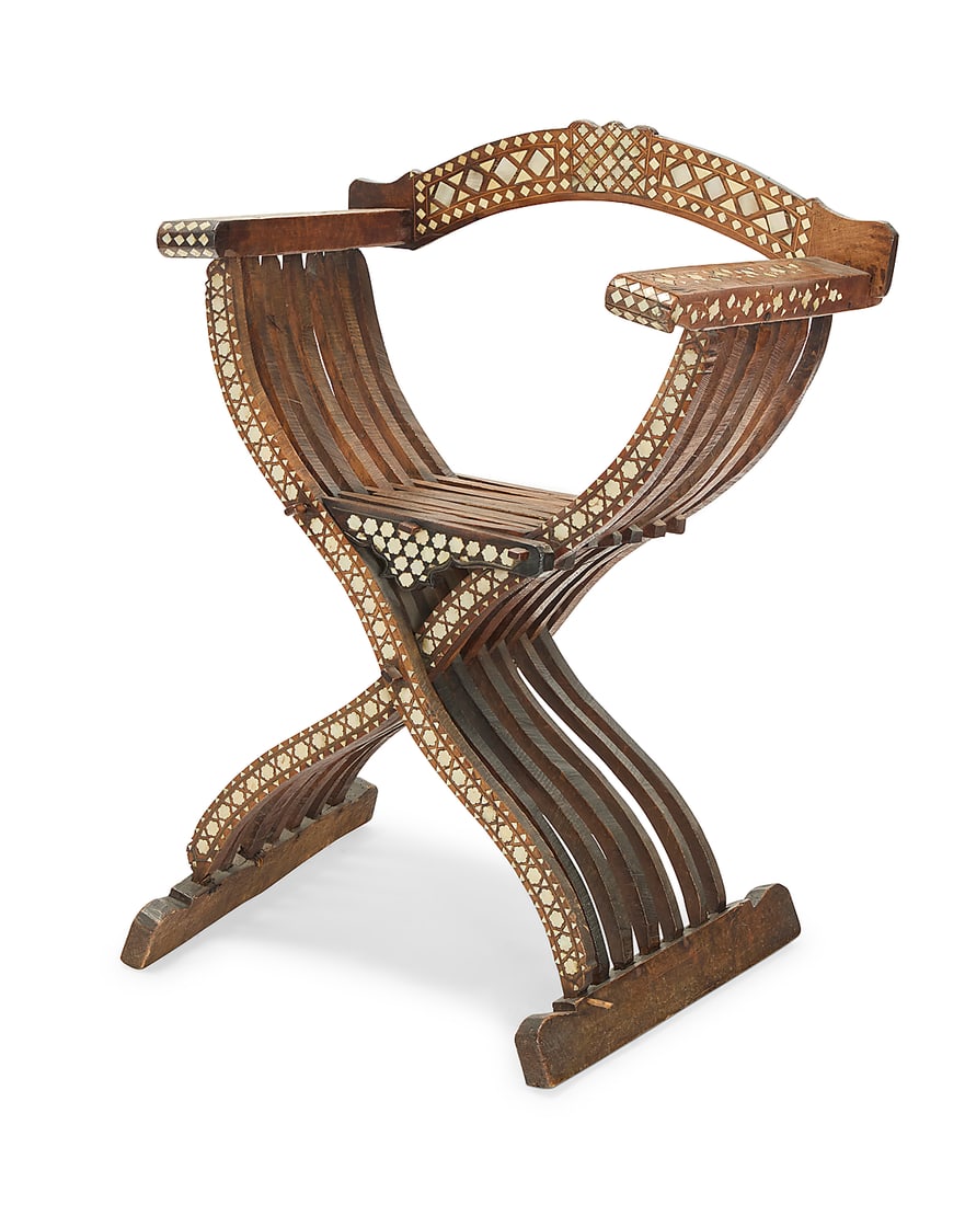A Levantine inlaid carved hardwood savonarola chair: A Levantine inlaid carved hardwood savonarola chair 19th/20th century With curved supports and a slatted seat and back, profusely inlaid with bone and mother-of-pearl elements arranged in geometric