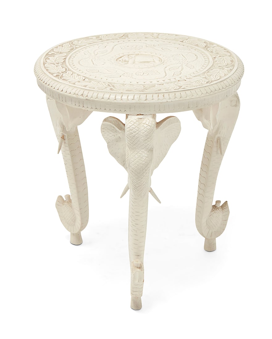 An Anglo-Indian style white painted occasional table: An Anglo-Indian style white painted occasional table 20th century The white painted carved wood table raised on three elephant-form legs, the tabletop carved with elephant and floral motifs centering