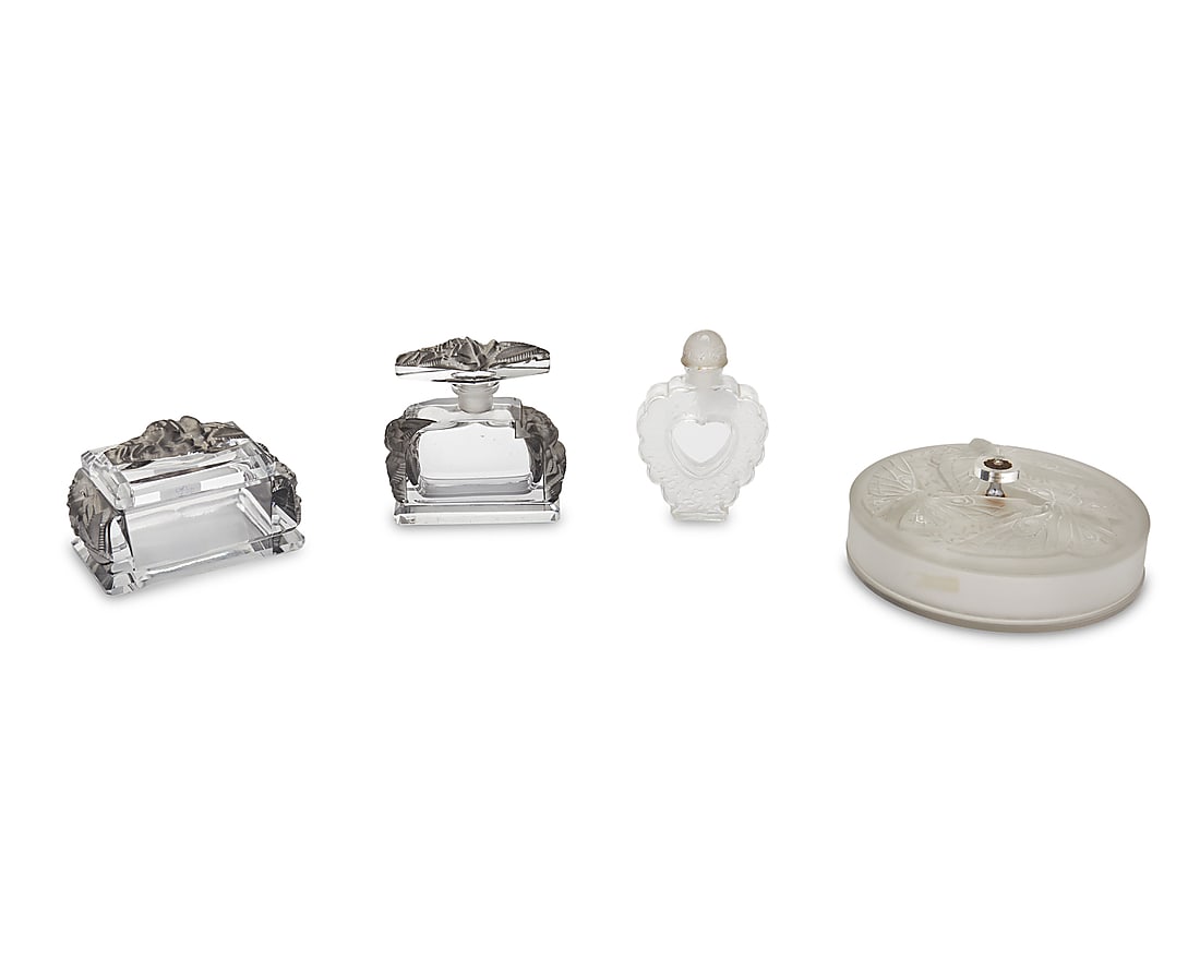 A group of art glass vanity items: A group of art glass vanity items 20th Century One signed: Verlys; one signed: Bottle Made by Lalique France / Coeur Joie / Nina Ricci Comprising a clear and frosted glass Verlys powder box with