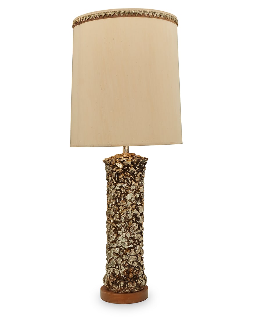 A Modern silvered ceramic table lamp: A Modern silvered ceramic table lamp Late 20th century Unmarked The cylindrical base in the form of stacked stones, issuing a single light, surmounted by a cylindrical fabric shade with passementerie 