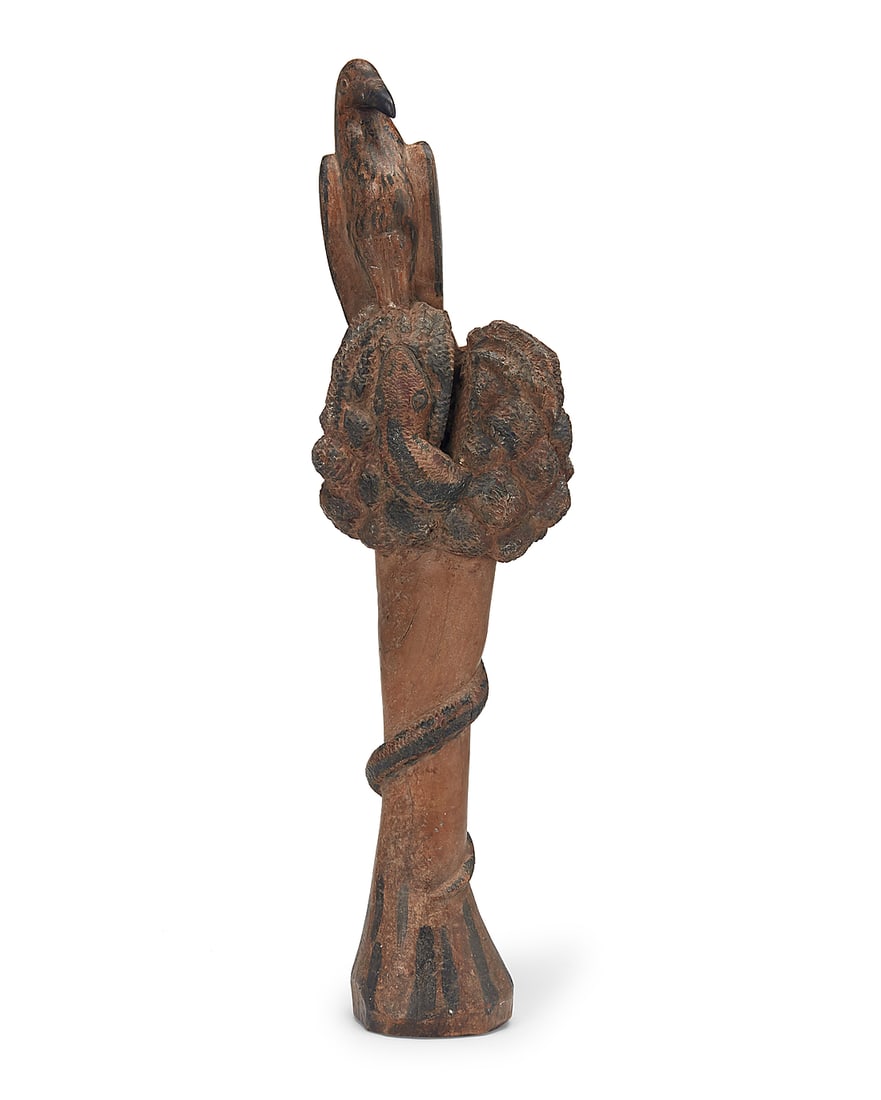 A Folk Art wood carving of an eagle and snake: A Folk Art wood carving of an eagle and snake 19th/20th century The partially painted carving depicting an eagle perched atop a tree or bush with an approaching snake coiled around 27.125" H x 7.25"