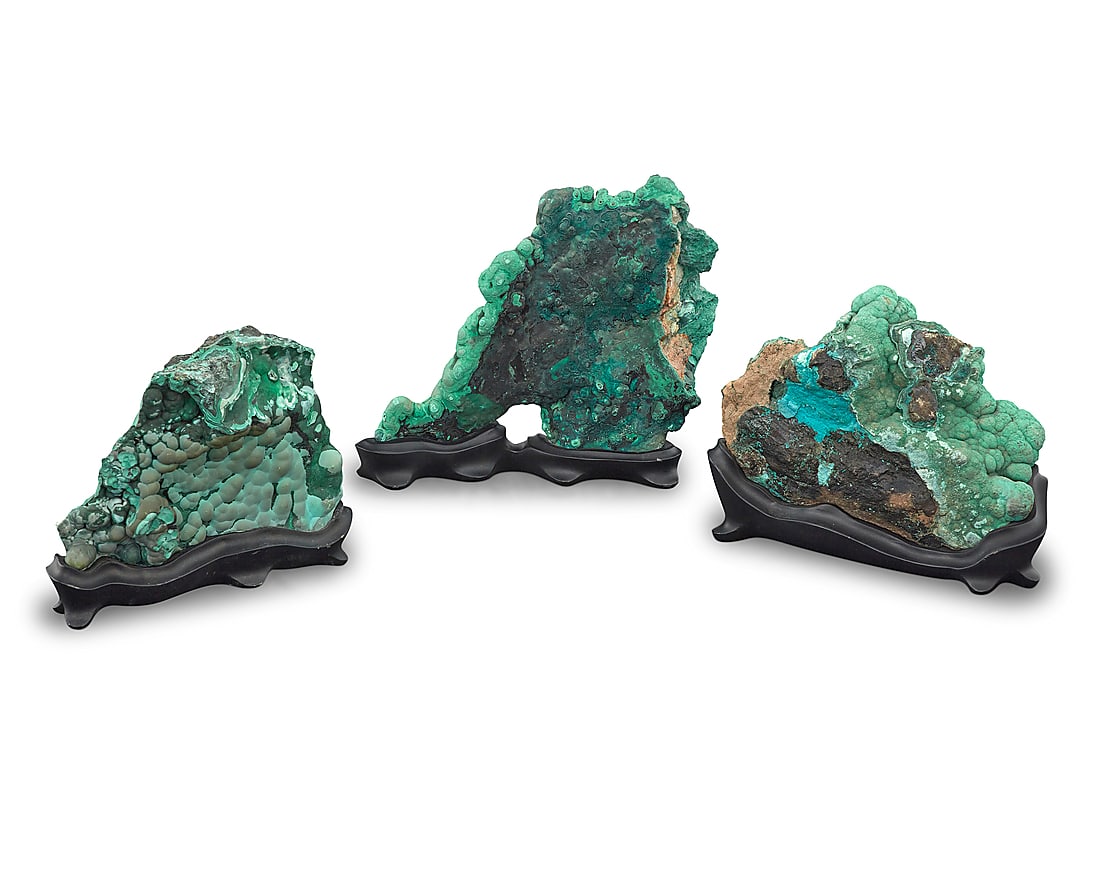 Three malachite specimens: Three malachite specimens Democratic Republic of the Congo The largest with botryoidal growth, bull's eyes, and chatoyancy effect on the reverse side, each raised on a custom-fitted black stand 3