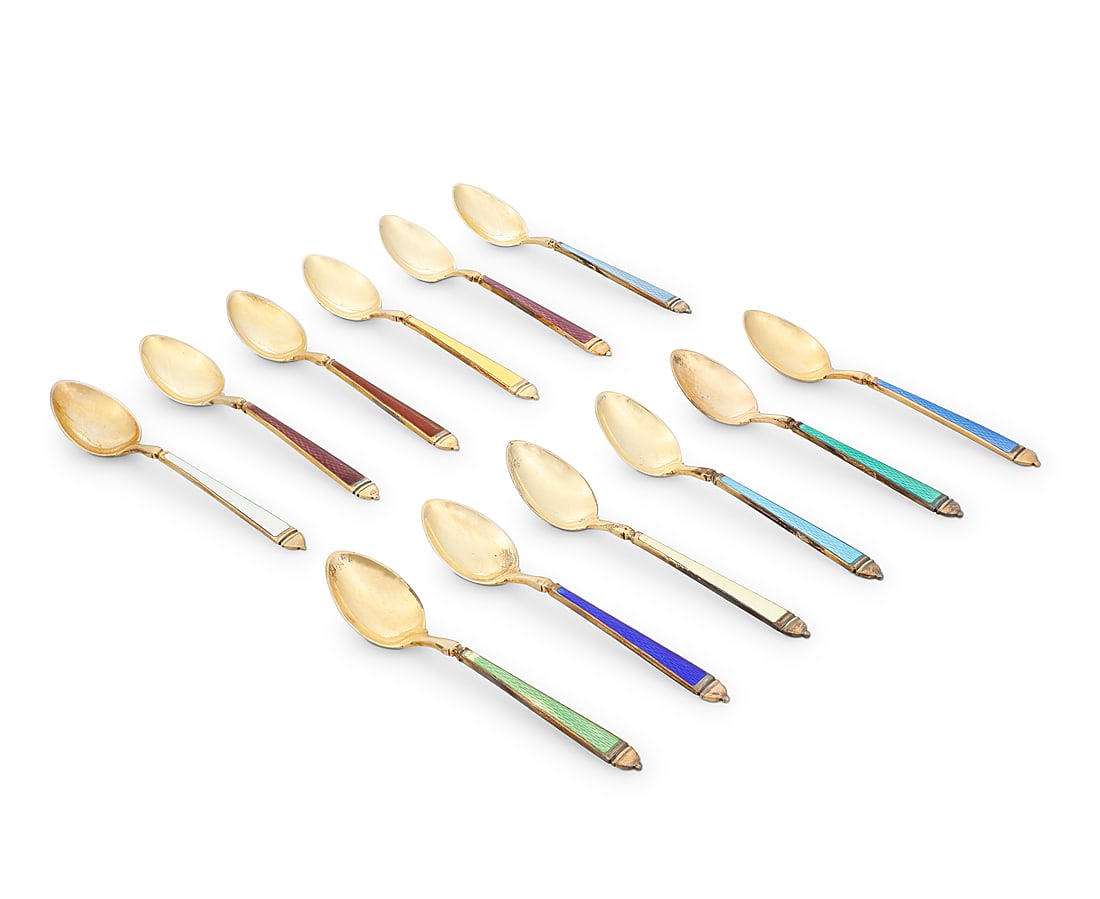 A set of twelve Cartier sterling silver gilt and enamel demitasse spoons: A set of twelve Cartier sterling silver gilt and enamel demitasse spoons Second/third quarter 20th century Each marked for Watson and for sterling Retailed by Cartier, each with gold wash and in origi