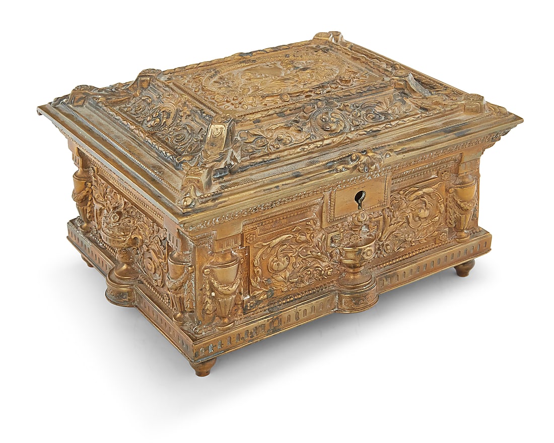 A Renaissance Revival brass jewelry box: A Renaissance Revival brass jewelry box Early 20th century, possibly Jennings Brothers The architectural box decorated with urns and profuse foliate motifs, the locking lid depicting Cupid and