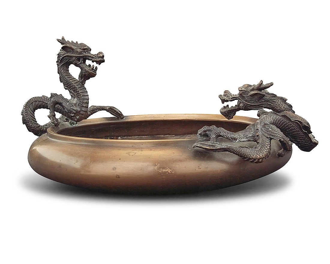 A Chinese bronze dragon bowl: A Chinese bronze dragon bowl 20th century Unmarked Mounted with two dragons Height 7 in., width 14 3/4 in., depth 12 1/2 in.