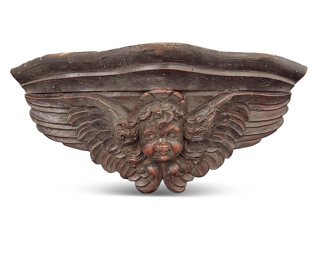 A Continental carved wood wall bracket: A Continental carved wood wall bracket Early 20th century Depicting a winged putti mask in relief Height 7 1/2 in., width 17 3/4 in., depth 7 1/2 in. Provenance: From the estate of Professor V. A. Kol