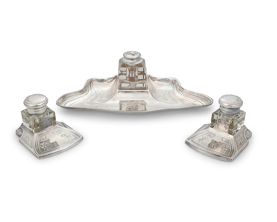 An Argenta silver plated ink stand: An Argenta silver plated ink stand Early 20th century Marked: ARGENTA XO; two associated inkwells marked: MADE IN PORTUGAL The Art Nouveau stand with glass bottle, together with two silver-plated meta