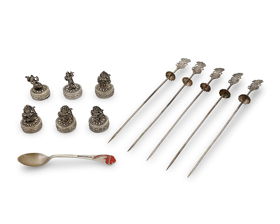A collection of Southeast Asian silvered metal and sterling objects: A collection of Southeast Asian silvered metal and sterling objects 20th century Each place card holder marked: CAMBODGE / T900; spoon marked: STERLING Comprising one Bangkok commemorative sterling si