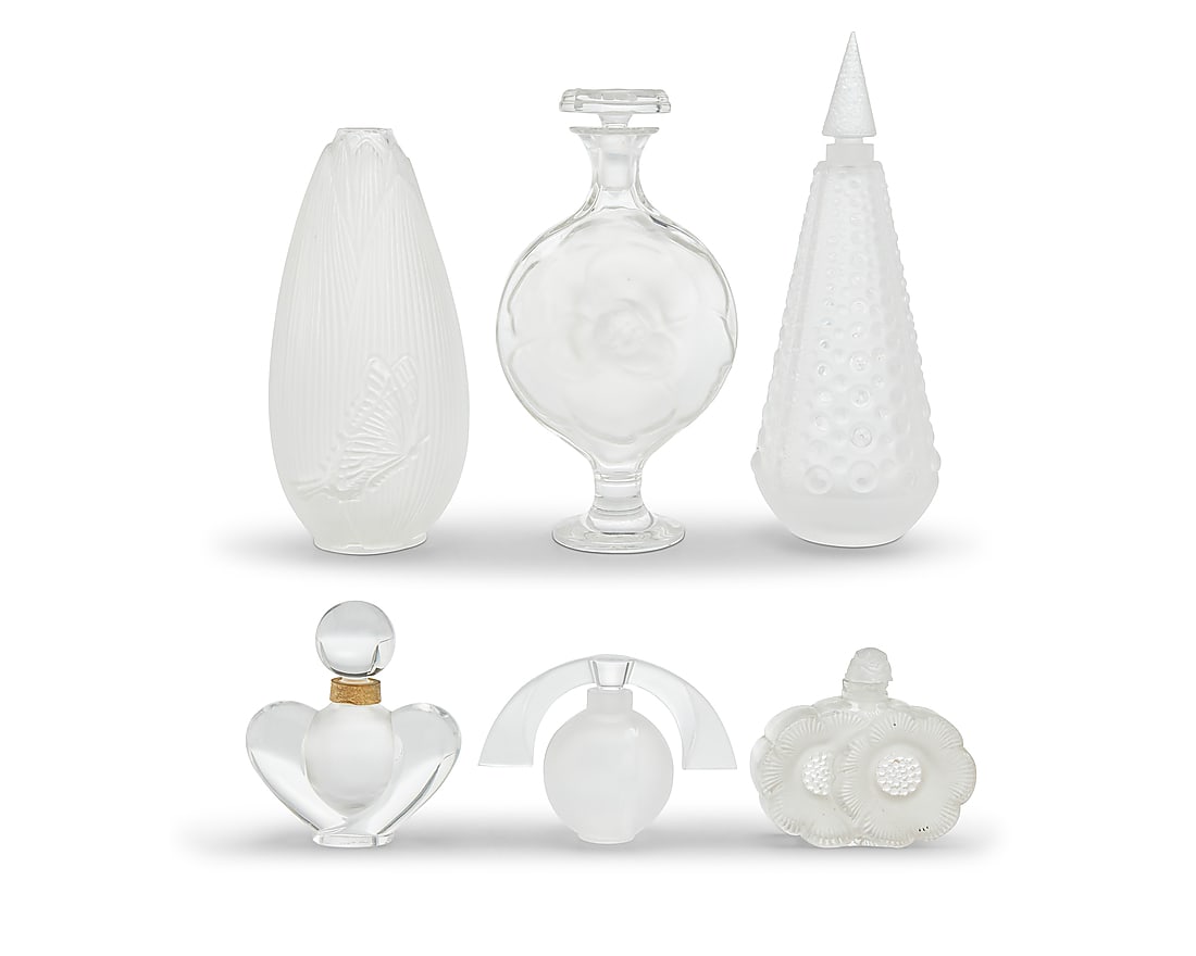 A group of five Lalique glass scent bottles and a vase: A group of five Lalique glass scent bottles and a vase Late 20th century Each etched: Lalique ® France Comprising perfume bottles 'Deux Fleurs,' 'Eclipse,' 'Perles,' 'Moulin Rouge,' and Nina Ricci 'F
