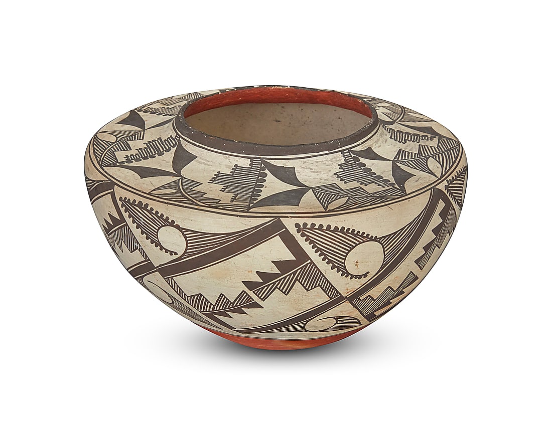 An Acoma Pueblo polychrome pottery jar: An Acoma Pueblo polychrome pottery jar First half 20th century With black fine-line and geometric motifs on white slip ground above a terracotta wash and puki indentation Height 5 3/4 in., diameter 9 