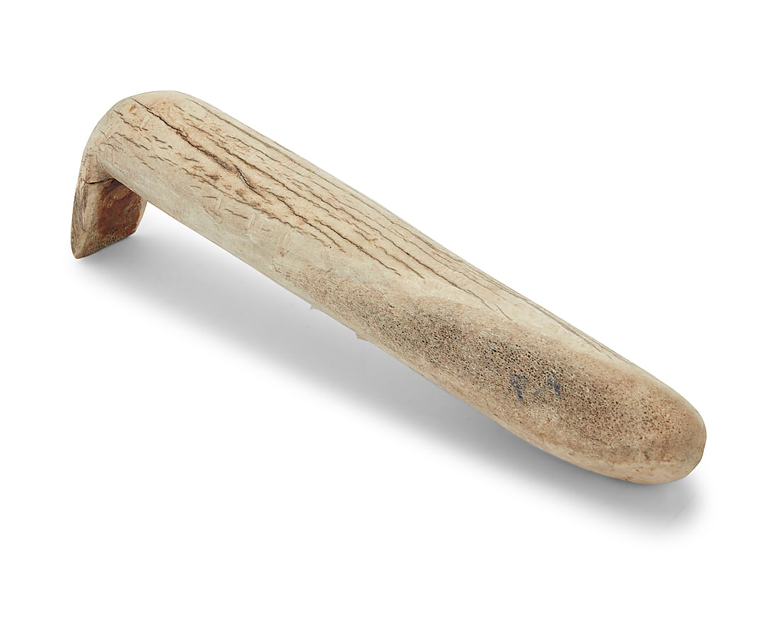 An elk horn hide scraper: An elk horn hide scraper 20th century The long cylindrical antler scraper with carved scraper 'foot' to one end Height 11 3/4 in., width 2 in., depth 3 1/2 in. approximately