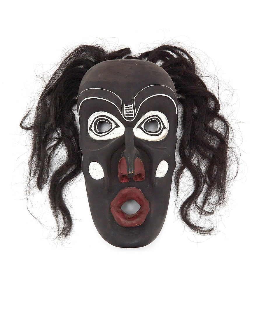 A Northwest Coast polychrome carved cedar 'Dzunuk'wa' mask: A Northwest Coast polychrome carved cedar 'Dzunuk'wa' mask Second half 20th century A likely Kwakwaka'wakw (Kwakiutl) Tsonoqua mask in black, red, and white pigment, with black hair, likely depicting