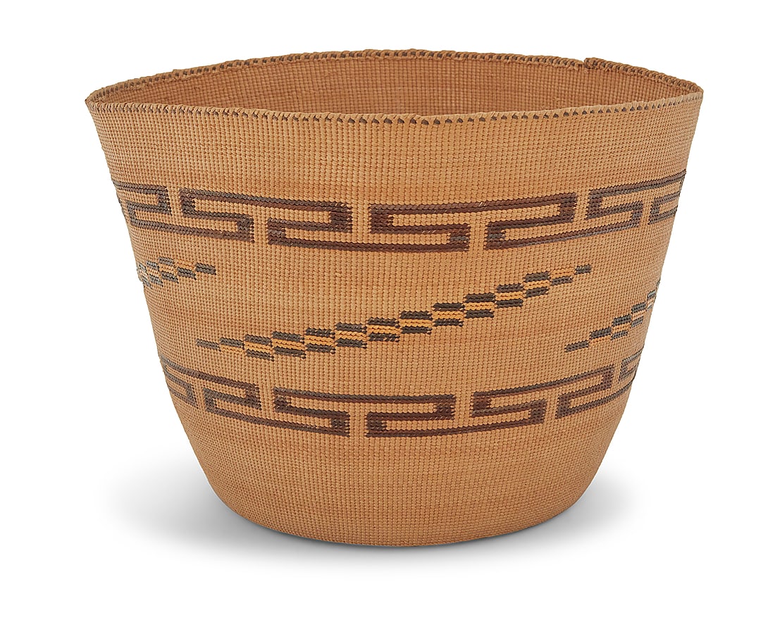 A Tlingit polychrome basket: A Tlingit polychrome basket 20th century; Pacific Northwest Coast A finely twined berry basket with 'false embroidery' designs worked in fretwork bands and diagonal stepped panels to the sides Height