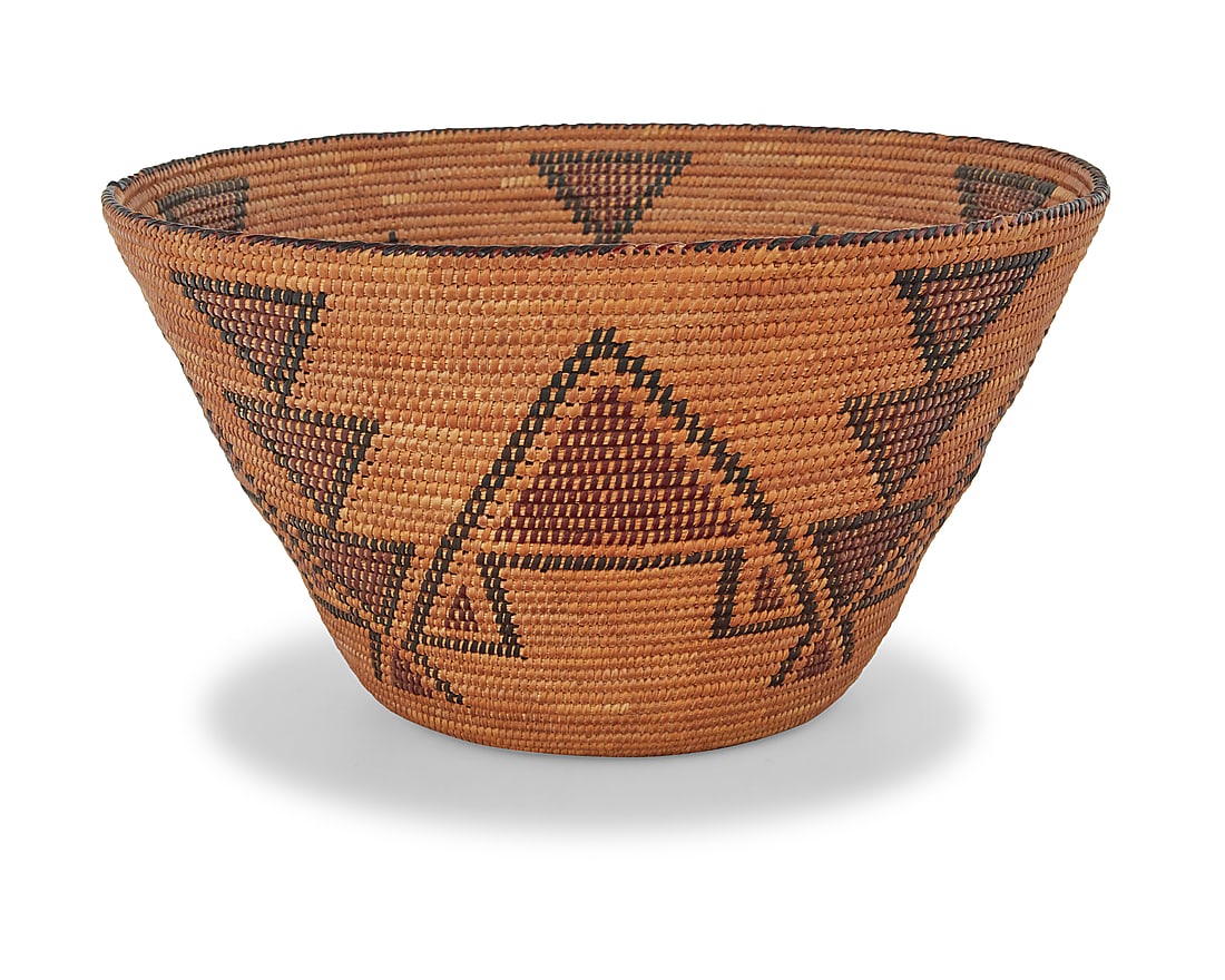 A Yokuts polychrome basketry bowl: A Yokuts polychrome basketry bowl Early/mid-20th century; Central California The tall coiled tapered basket with five stacked triangular columns alternating with large stepped triangles and contrast d