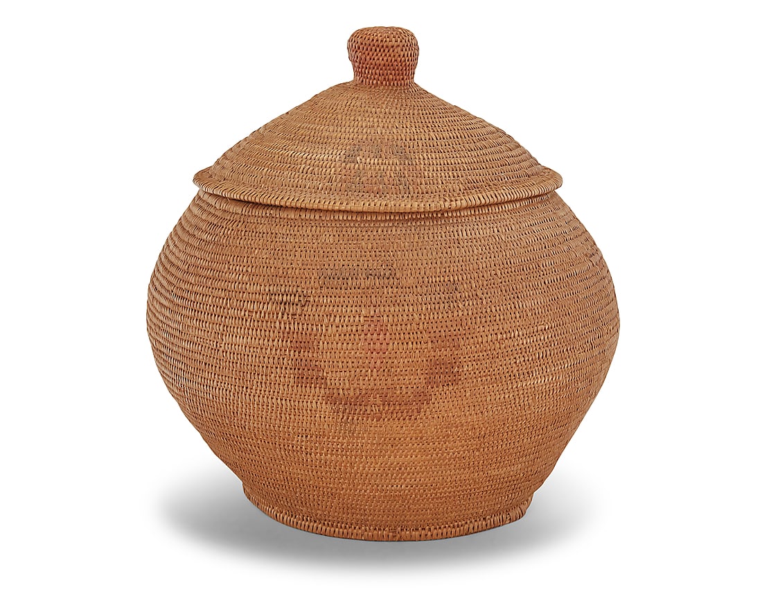 A large Paiute polychrome storage basket: A large Paiute polychrome storage basket Second quarter 20th century; Great Basin A large polychrome coiled globular basketry jar with large shaped knobbed lid, featuring four polychrome stylized