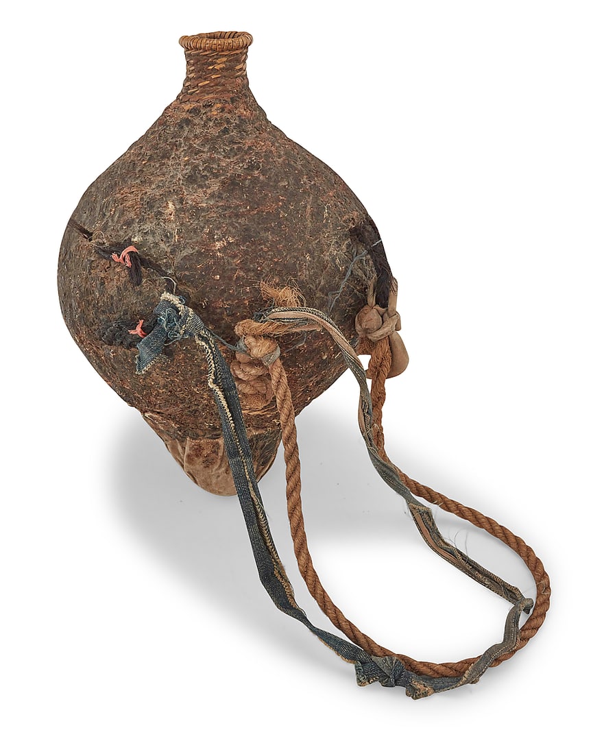 An Apache pitch-sealed basketry water vessel: An Apache pitch-sealed basketry water vessel Late 19th/early 20th century; Southeast United States A large twined tapered conical bottle-neck jar sealed with pine resin pitch, with canvas to the