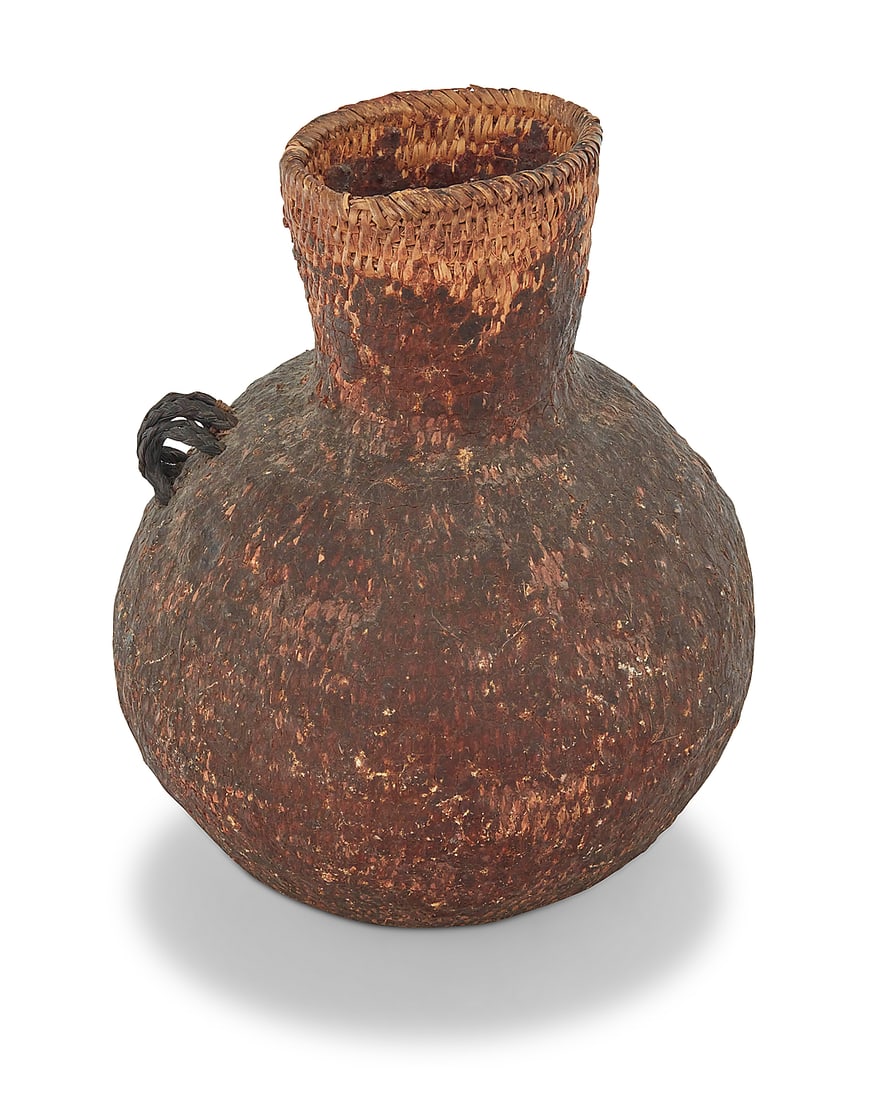 An Apache pitch-covered basketry vessel: An Apache pitch-covered basketry vessel Late 19th/early 20th century; Southeast United States A large coiled basketry water jar coated in pine pitch, with two multi-strand braided horsehair handles