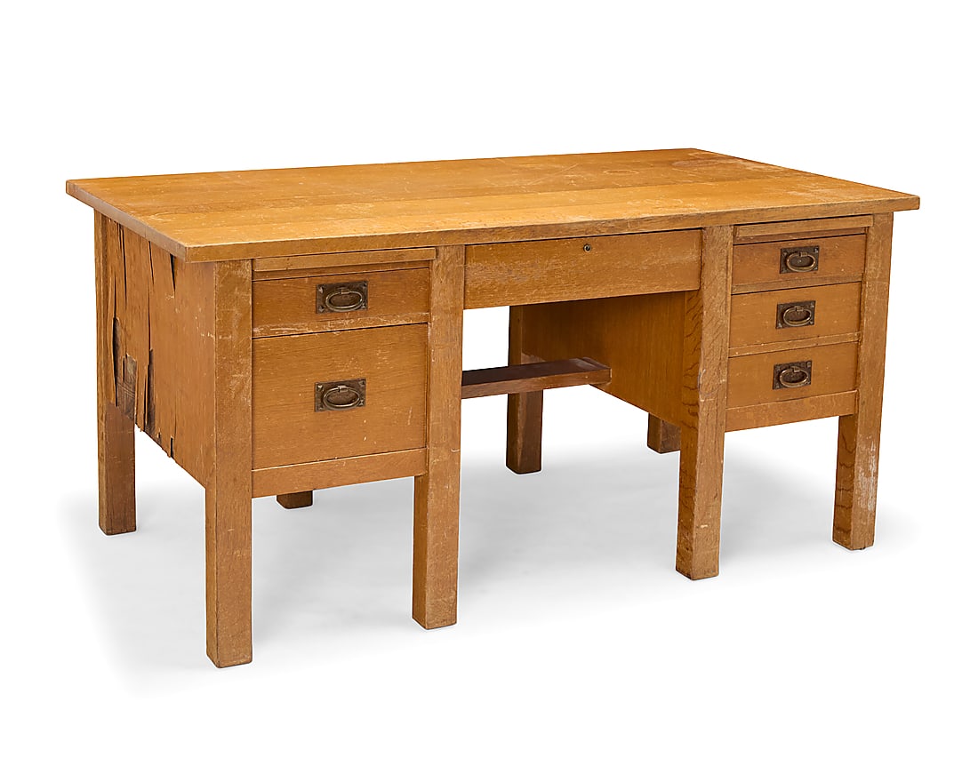 A Gustav Stickley oak desk, model 711: A Gustav Stickley oak desk, model 711 1907-1912; Eastwood, NY The oak desk with rectangular top over a central lockable drawer flanked by two writing slides above a series of drawers with hammered