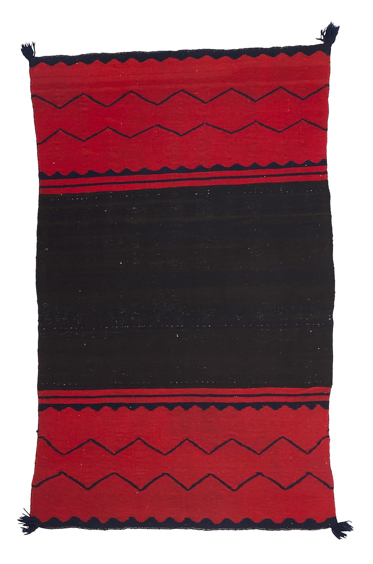 A Dine (Navajo) Classic period half dress: A Dine (Navajo) Classic period half dress Third quarter 19th century A single panel worked in wide red bands to each end with contrast zigzags and scalloped narrow banding and fringed corners, woven