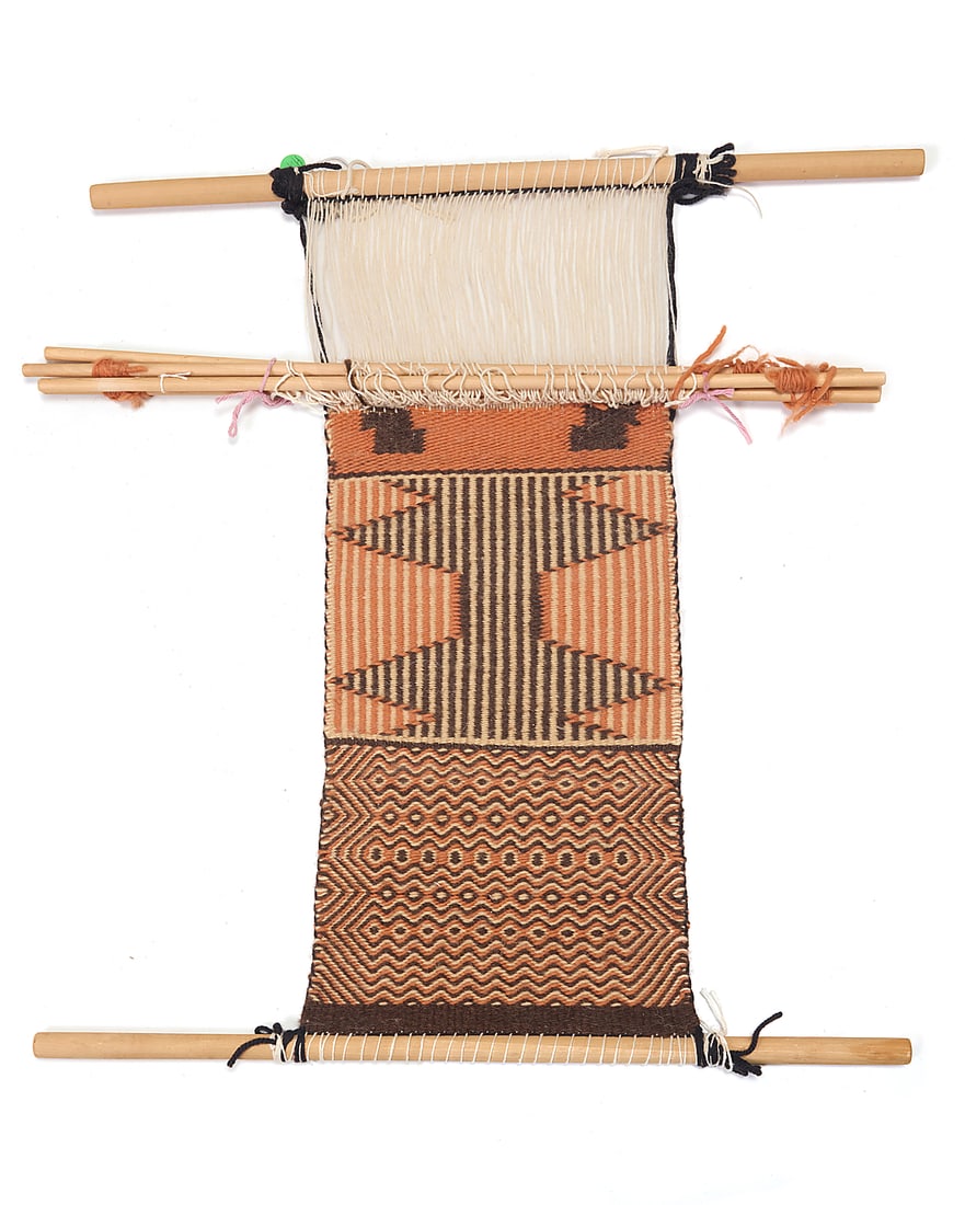 A Dine (Navajo) two-faced twill loomer: A Dine (Navajo) two-faced twill loomer Second half 20th century Featuring a double weave in-progress sampler with various twill patterns, woven in brown, orange, and cream wool yarn with wool warps,