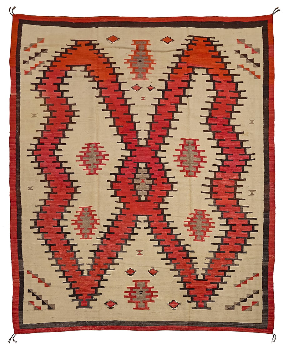 A large Dine (Navajo) rug: A large Dine (Navajo) rug Mid-20th century Woven in cream, red, brown, and grey wool, with a central medallion taking the form of an abstract butterfly, with additional diamonds and stepped devices, f