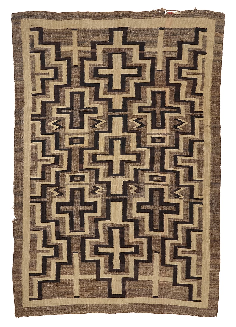 A Dine (Navajo) regional rug: A Dine (Navajo) regional rug First half 20th century Woven in natural cream, brown, and mottled brown wool featuring three columns of interlocking stacked concentric crosses with floating zigzags and 