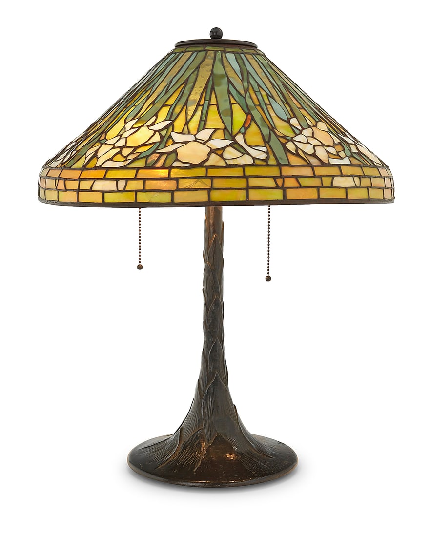 A Tiffany-style glass and metal 'Daffodil' table lamp: A Tiffany-style glass and metal 'Daffodil' table lamp Late 20th century, Gunther Lambert Collection The leaded glass shade depicting floral motifs, on a Gunther Lambert Collection lamp base issuing th
