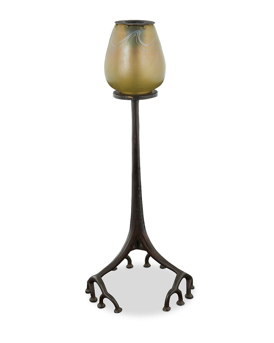 A Tiffany Studios bronze 'Root' candlestick: A Tiffany Studios bronze 'Root' candlestick Early 20th century with later married elements The root-form base with altered support raising an associated iridescent pulled feather glass shade
