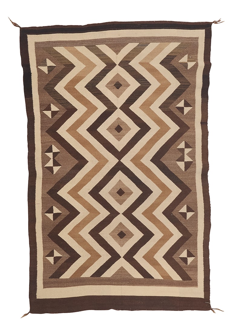 A fine Dine (Navajo) Two Grey Hills rug: A fine Dine (Navajo) Two Grey Hills rug First half 20th century Finely woven in brown, cream, tan, and mottled brown wool with a central column of stacked diamonds with concentric zigzags and floating