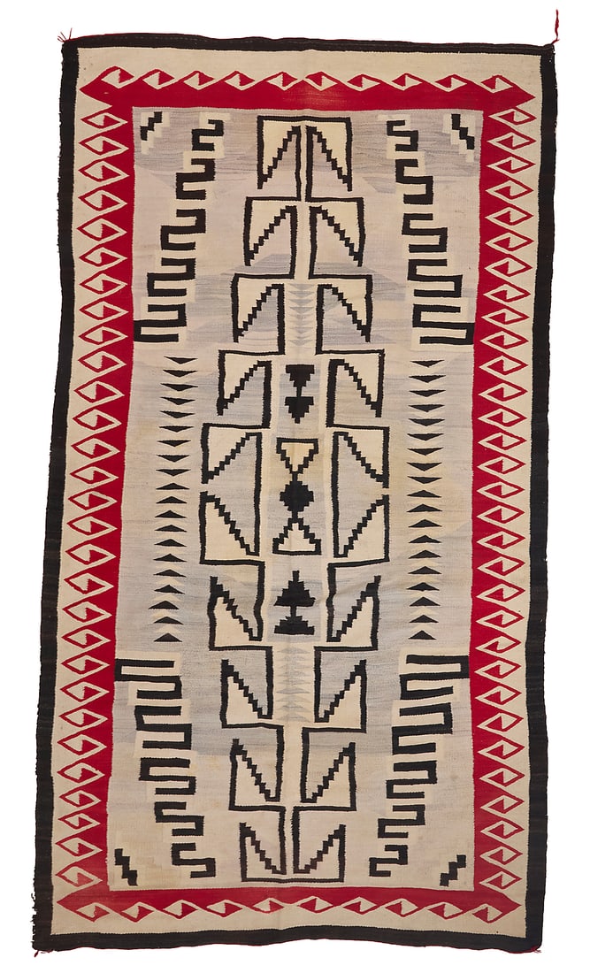 A large Dine (Navajo) regional rug: A large Dine (Navajo) regional rug Second half 20th century Woven in brown, cream, red, and pale grey wool with a central elongated stepped hooked diamond with floating stepped elements within and fla