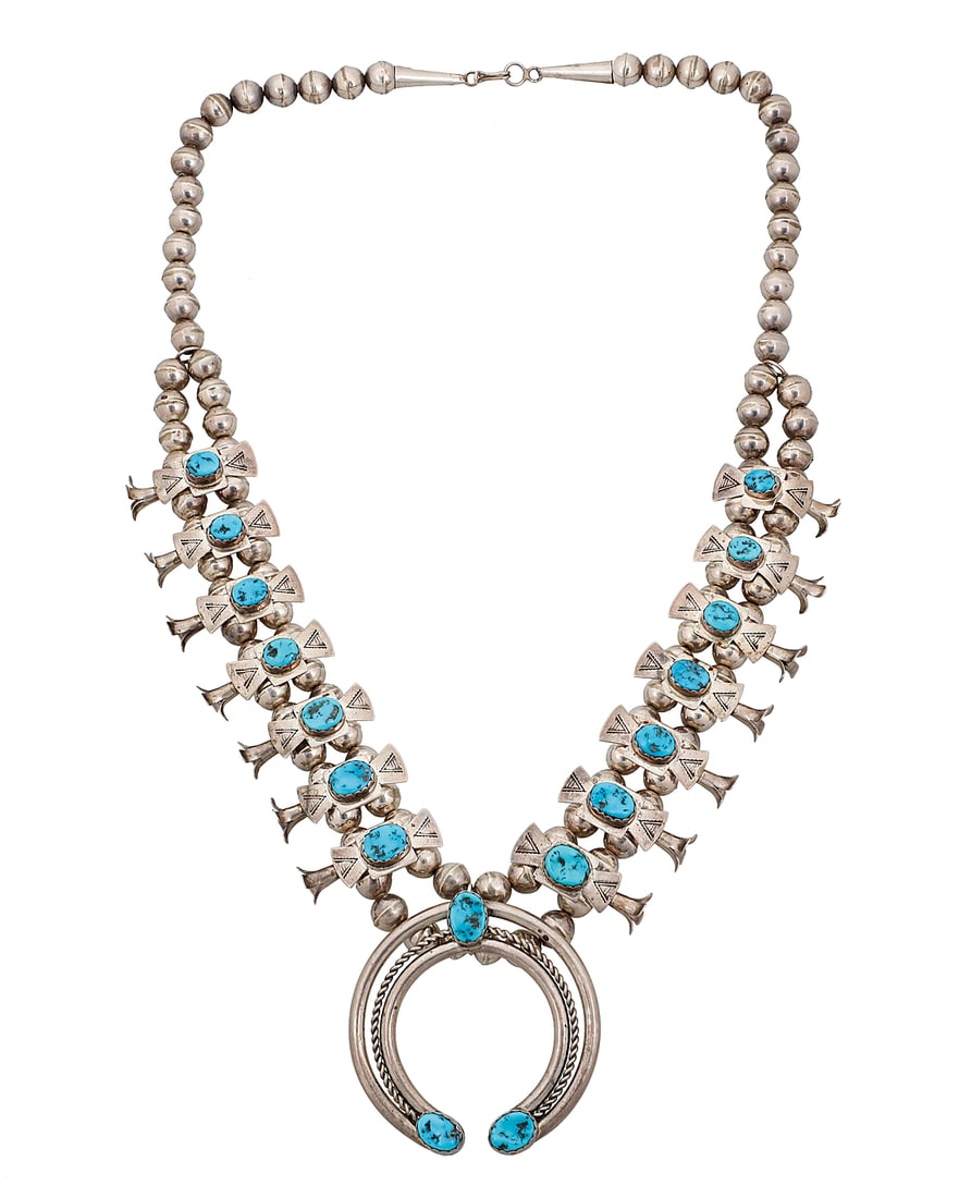 A Dine (Navajo) or Zuni 'Box & Bow' squash blossom necklace: A Dine (Navajo) or Zuni 'Box & Bow' squash blossom necklace Late 20th/21st century With fourteen stamped sterling silver 'box and bow' blossoms, each with graduated set turquoise, and a central set