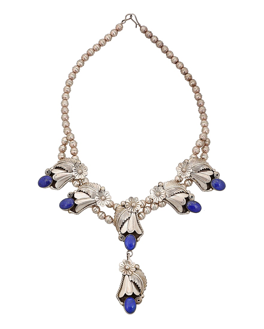 A Southwest sterling silver and lapis lazuli squash blossom necklace: A Southwest sterling silver and lapis lazuli squash blossom necklace A small squash blossom-style necklace with five ornate blossoms with set lapis lazuli, suspending a matching pendant, all on a doub