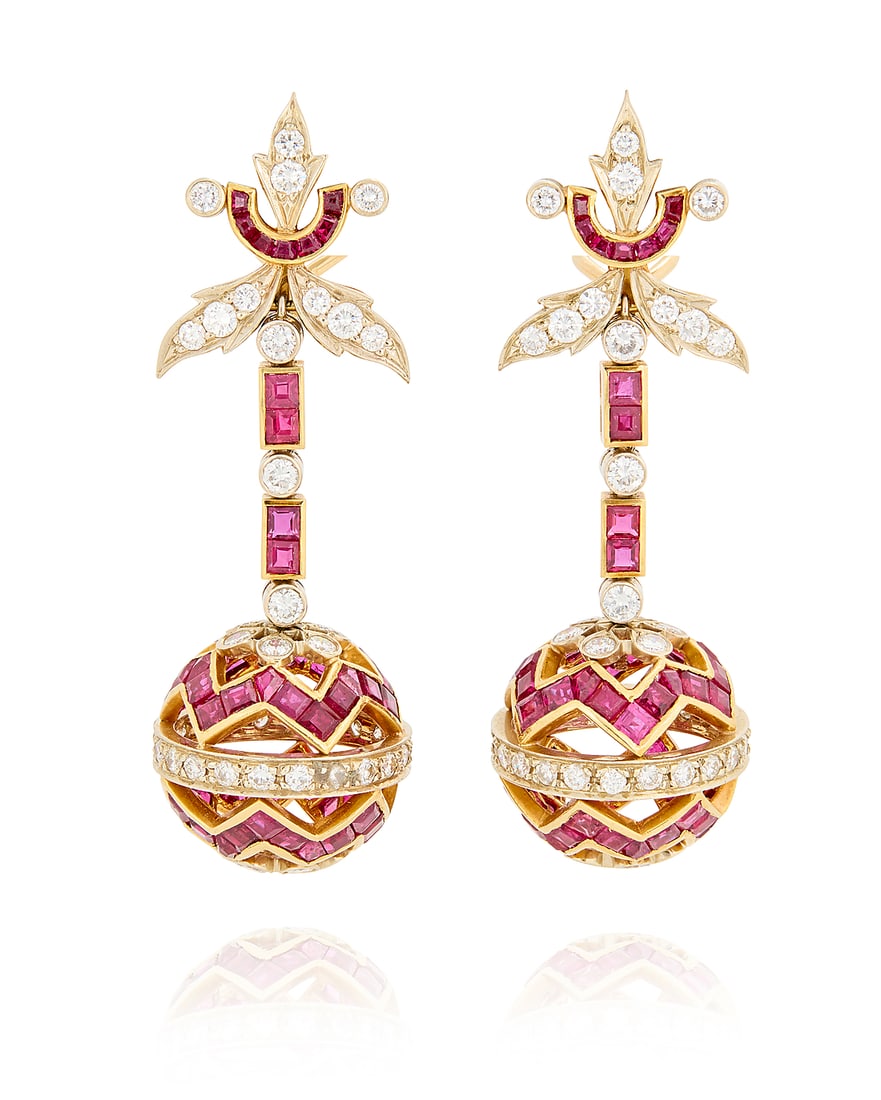 A Pair of 14K Gold, Ruby and Diamond Earrings Of a pendant design featuring a floral motif: A Pair of 14K Gold, Ruby and Diamond Earrings Of a pendant design featuring a floral motif suspending a sphere all set with square-cut rubies and accented by round diamonds weighing approximately 5.20
