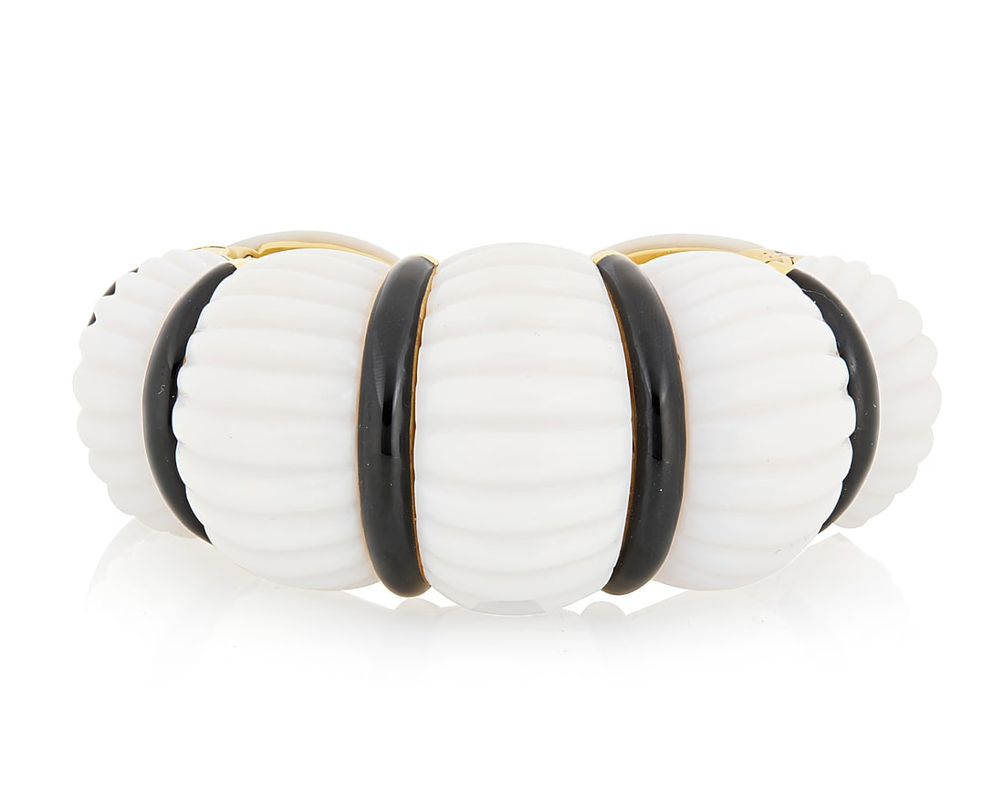David Webb: An 18K Gold, Coral and Enamel Cuff Featuring carved domed elements of white coral,: David Webb: An 18K Gold, Coral and Enamel Cuff Featuring carved domed elements of white coral, accented by bands of black enamel, with two hinged ends, signed Webb Measures: 5 3/4 in., Gap: 5/8 in. 20