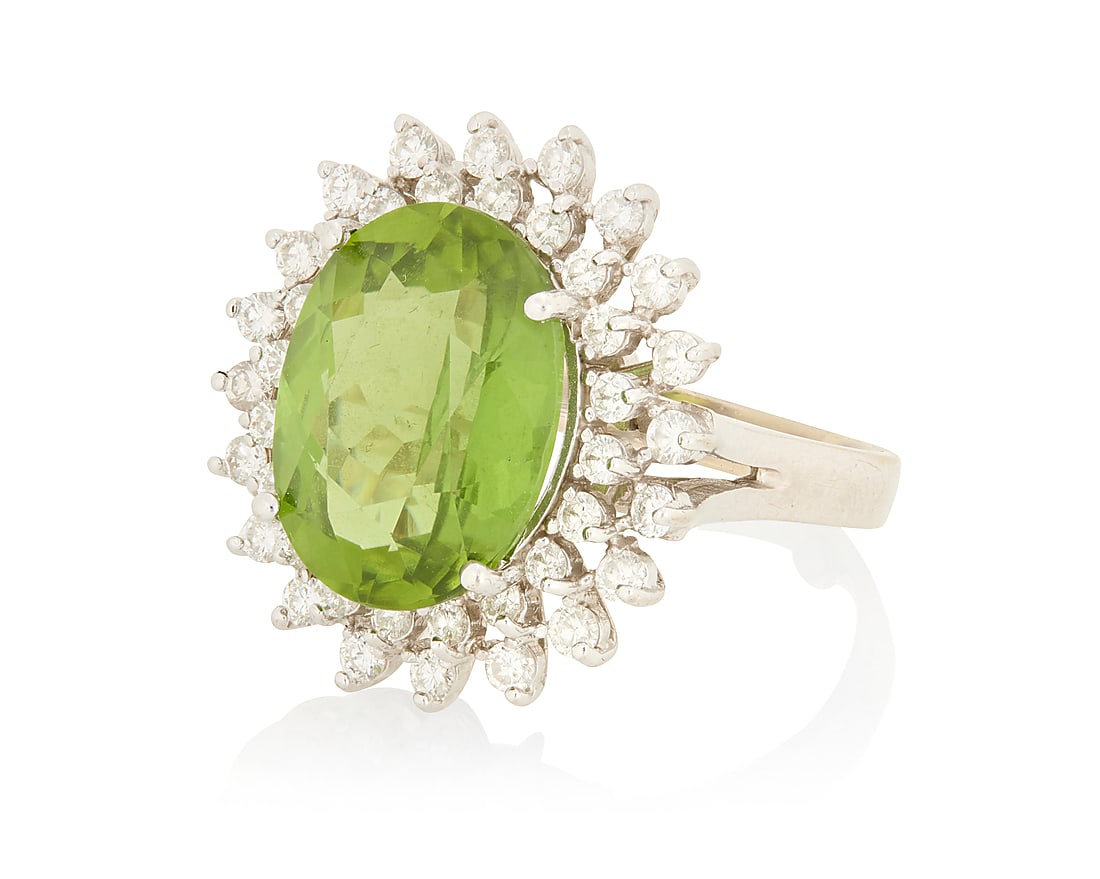 A 14K White Gold, Peridot and Diamond Ring Centering an oval peridot weighing approximately 10.35 (1 of 3)