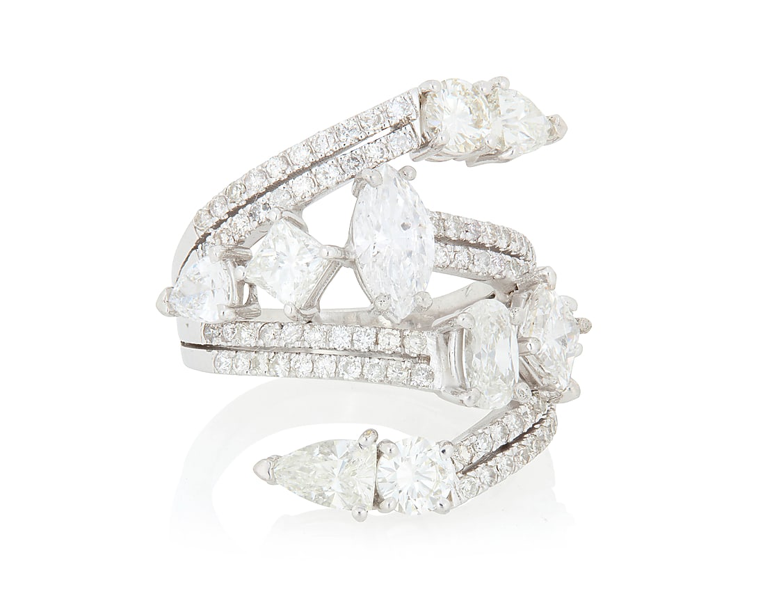 An 18K White Gold and Diamond Ring Of a bypass design featuring round, oval, pear-shaped and (1 of 4)