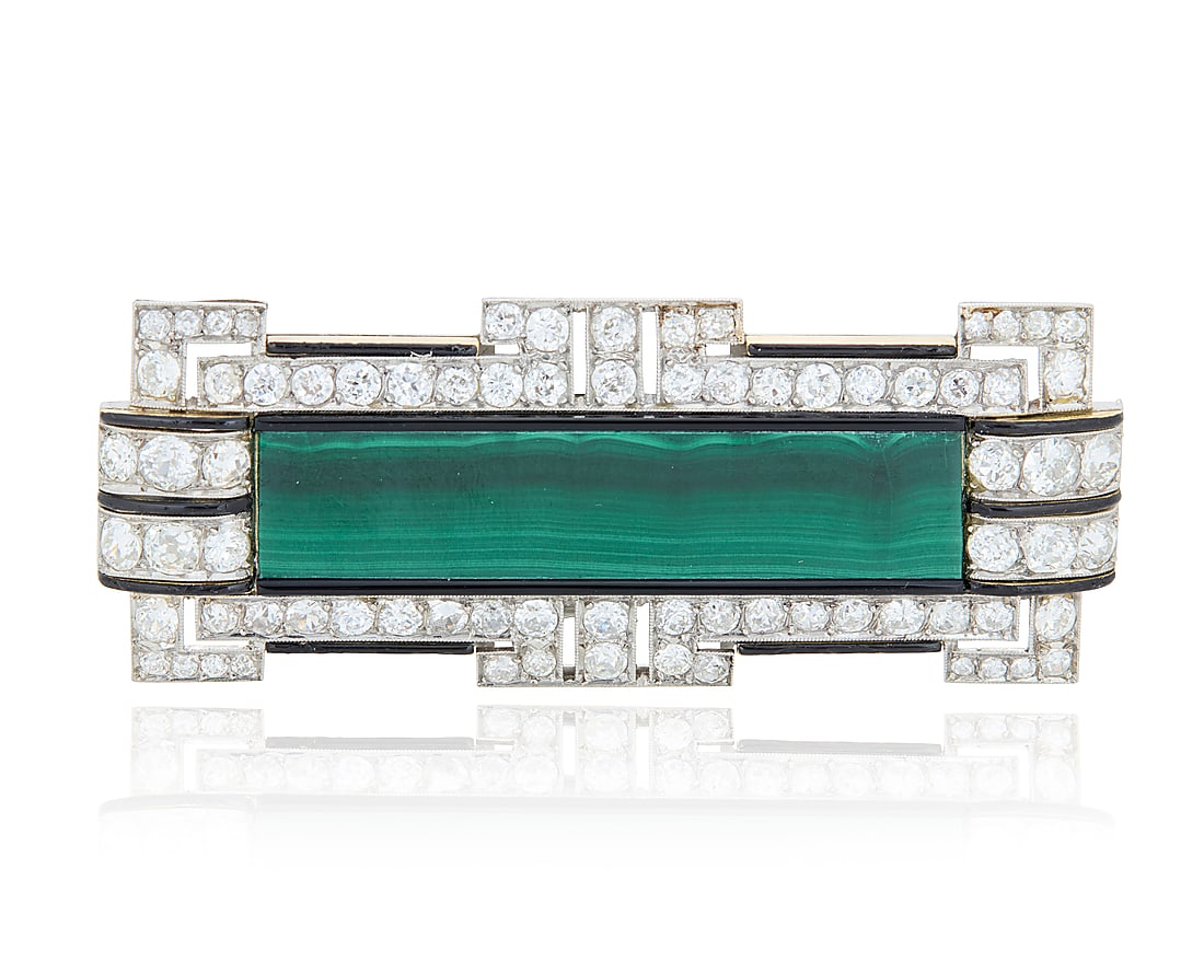 A Platinum, Malachite and Diamond Pin Of an elongated geometric design centering a rectangular: A Platinum, Malachite and Diamond Pin Of an elongated geometric design centering a rectangular malachite tablet, accented by onyx and black enamel, finished with old European-cut and old Mine-cut diam