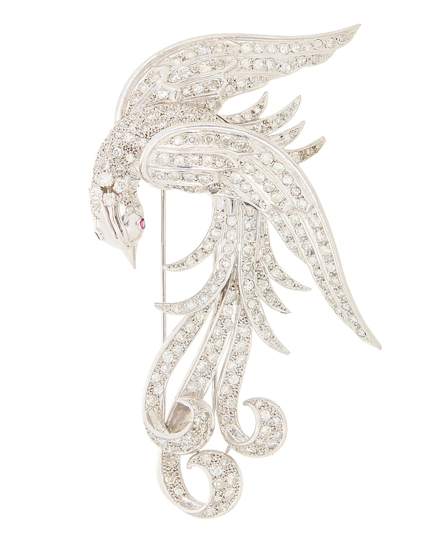 A 14K White Gold and Diamond Bird Brooch Of a bird design with cascading feather set with: A 14K White Gold and Diamond Bird Brooch Of a bird design with cascading feather set with single-cut diamonds weighing approximately 9.60 carats, finished with two single-cut ruby eyes Measures: 3 1/2