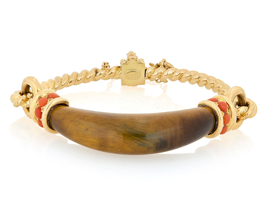 Chaumet: An 18K Gold, Tiger's Eye and Coral Bracelet Featuring a carved domed tiger's eye: Chaumet: An 18K Gold, Tiger's Eye and Coral Bracelet Featuring a carved domed tiger's eye element, accented by ten round coral cabochons, flanked by a twisted rope design, signed Chaumet, Paris Inner 