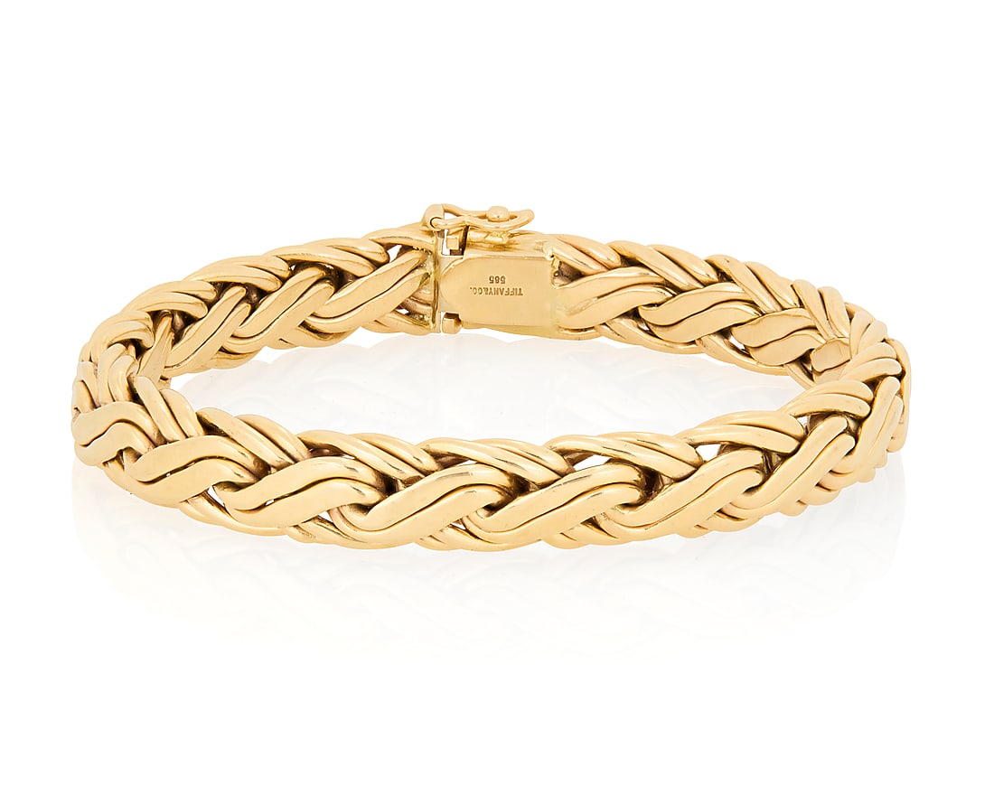 Tiffany & Co.: A 14K Gold Bracelet Of a fancy braided link design, signed Tiffany & Co., with: Tiffany & Co.: A 14K Gold Bracelet Of a fancy braided link design, signed Tiffany & Co., with signed box Length: 7 3/4 in., Width: 3/8 in. 24.3 grams gross
