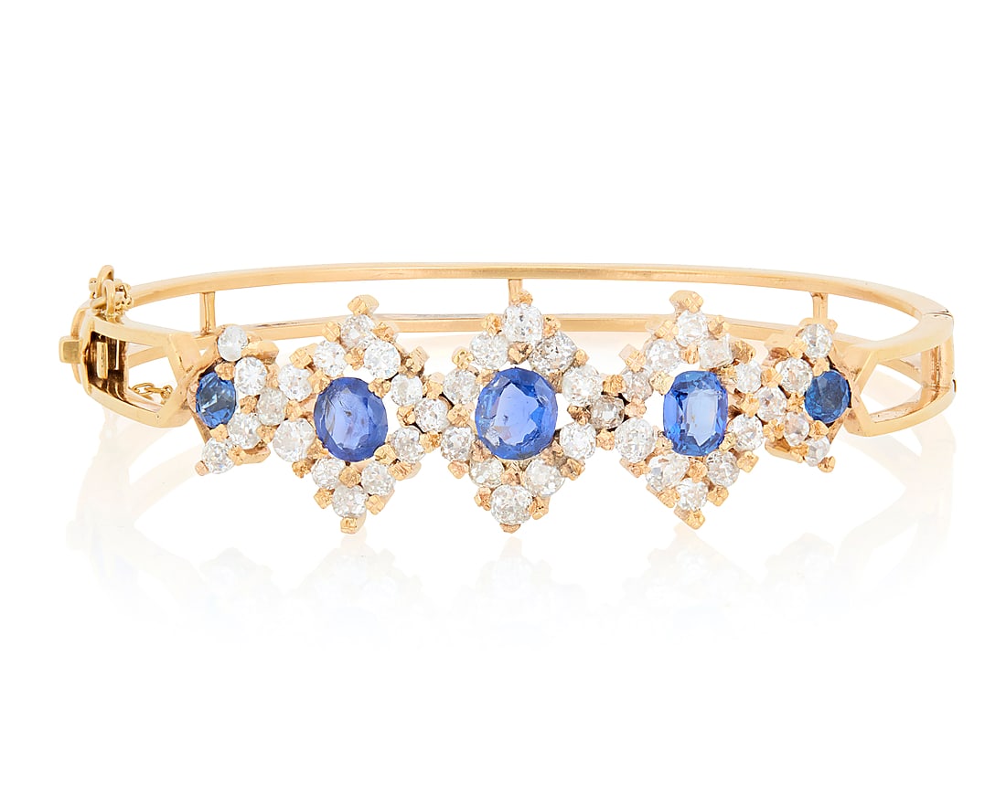 An 18K Gold, Sapphire and Diamond Bracelet Of a hinged design featuring kite shaped motifs set (1 of 3)